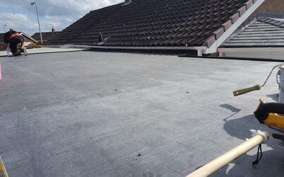 Professional flat roof fitting on property extension with seamless installation