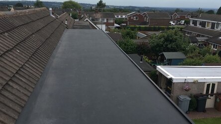 Professional flat rubber roofing installation on dormer extension showing seamless finish