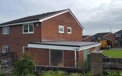 Detached garage with newly installed flat rubber roofing providing weather protection