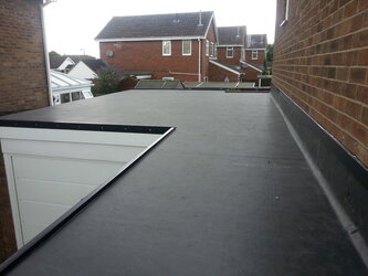 Complex L-shaped flat roof installation showcasing expert craftsmanship and rubber membrane
